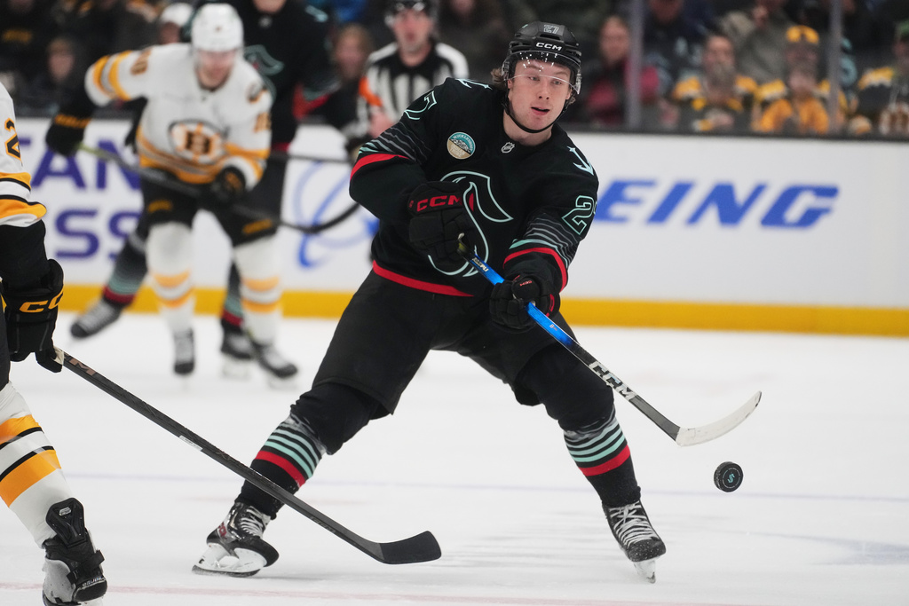 Seattle Kraken center Berkly Catton flicks the puck while facing the Boston Bruins during the third period of an NHL hockey game Tuesday, Jan. 6, 2026, in Seattle. (AP Photo/Lindsey Wasson)