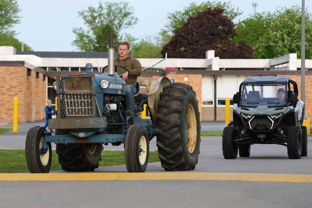 Gavin McFadden arrives on his Ford 5000 tractor during Tractor Day for graduating seniors at Airport High School Friday, May 22, 2026, in Carleton, Mich. (AP Photo/Paul Sancya)