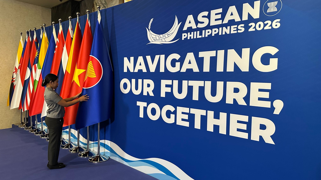 A woman adjusts the flag of the Association of Southeast Asian Nations (ASEAN) in Cebu, Philippines, Wednesday, Jan.28, 2026. (AP Photo/Joeal Calupitan)