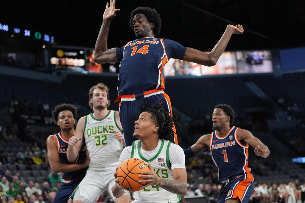 Oregon guard Jamari Phillips (24) looks to shoot as Auburn center Emeka Opurum (14) defends the play during the first half of an NCAA college basketball game in Las Vegas, Monday, Nov. 24, 2025. (AP Photo/Eric Gay)