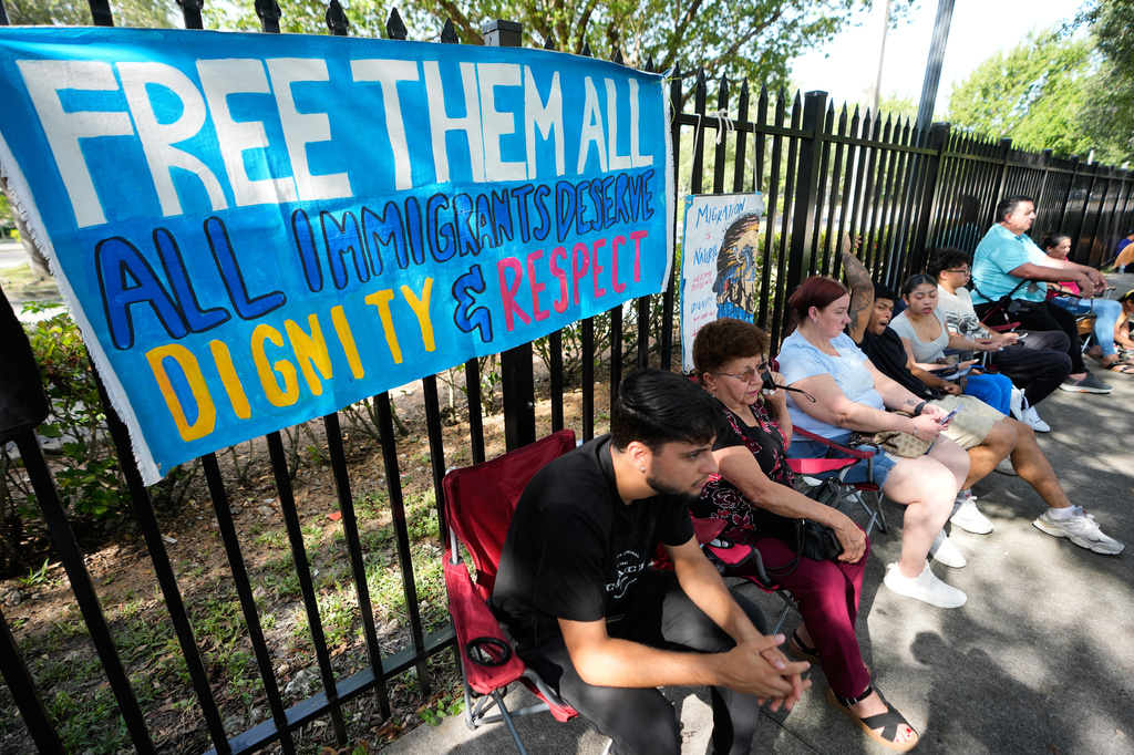 A man who asked not to be named, left, waits for news of his wife, who is from Cuba, as she has an appointment at the ICE Immigration and Customs Enforcement field office, Wednesday, July 1, 2026, in Miramar, Fla. (AP Photo/Lynne Sladky)