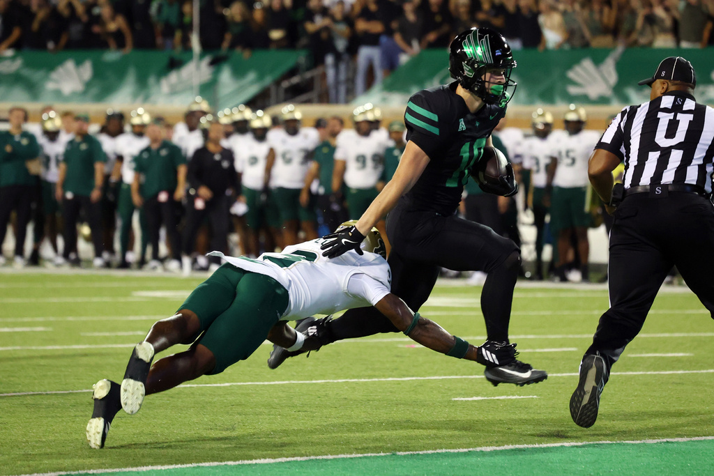 North Texas wide reciever Wyatt Young, second from left, scores a touchdown in the second quarter of an NCAA college football game against South Florida, Friday, Oct. 10, 2025, in Denton, Texas. (AP Photo/Richard W. Rodriguez)