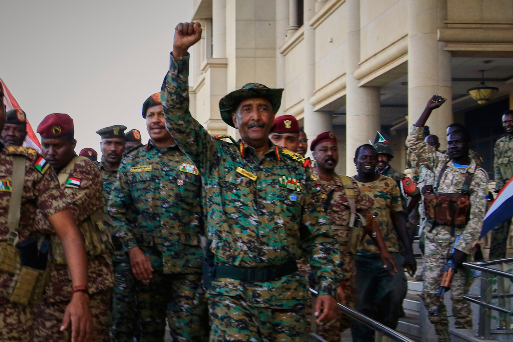 FILE - Sudan's military chief Gen. Abdel-Fattah Burhan, center, is greeted by troops as he arrives at the Republican Palace, recently recaptured from the Rapid Support Forces (RSF) paramilitary group, in Khartoum, Sudan, March 26, 2025. (AP Photo/File)