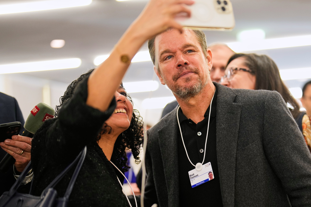 A woman makes a selfie with her phone with American actor Matt Damon during the Annual Meeting of the World Economic Forum in Davos, Switzerland, Tuesday, Jan. 20, 2026. (AP Photo/Markus Schreiber)