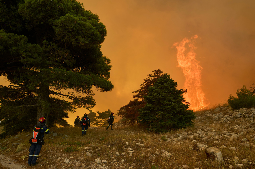 Firefighters approach towering flames on Mount Kithairon near Porto Germeno, northwest of Athens, Greece, Monday, Aug. 3, 2026. (AP Photo/Petros Giannakouris)