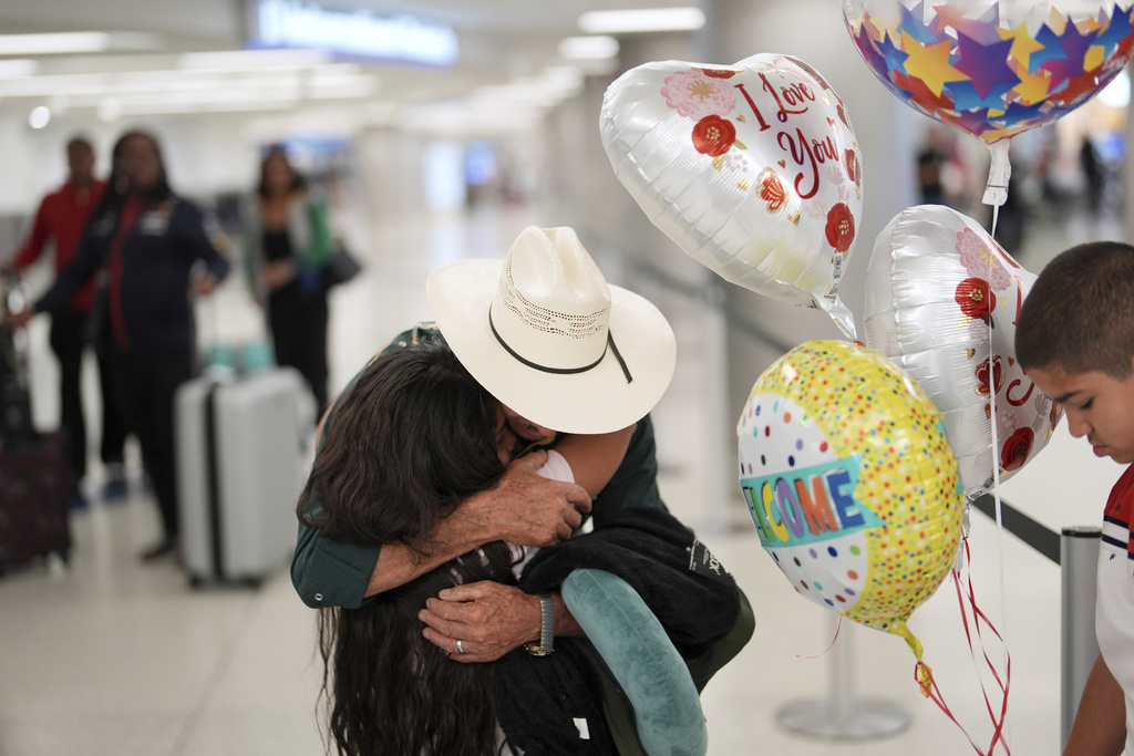 Alfredo de Jesus Reynoso Gonzalez, 73, center, greets two grandchildren he is meeting in person for the first time, as he and his wife arrive from Guatemala for a visit, at Miami International Airport, Monday, June 9, 2025, in Miami. (AP Photo/Rebecca Blackwell)