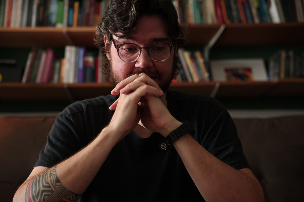 Teacher and businessman Diego Orsi cries while talking about his late cousin Henrique, who died of COVID-19, during an interview at his home, in Sao Paulo, Wednesday, Nov. 19, 2025. (AP Photo/Ettore Chiereguini)