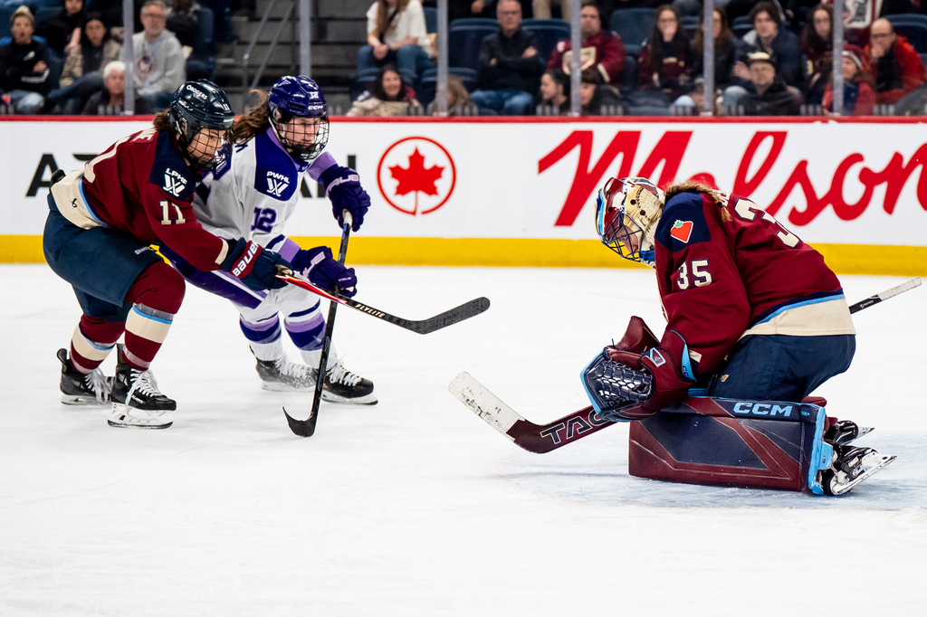 Montréal Victoire goaltender Ann-Renée Desbiens (35) makes a save against Minnesota Frost's Kelly Pannek (12) while Montréal Victoire's Abby Roque (11) defends, during second overtime period of an PWHL playoff hockey game in Laval, Que., on Tuesday, May 5, 2026. (Christopher Katsarov/The Canadian Press via AP)