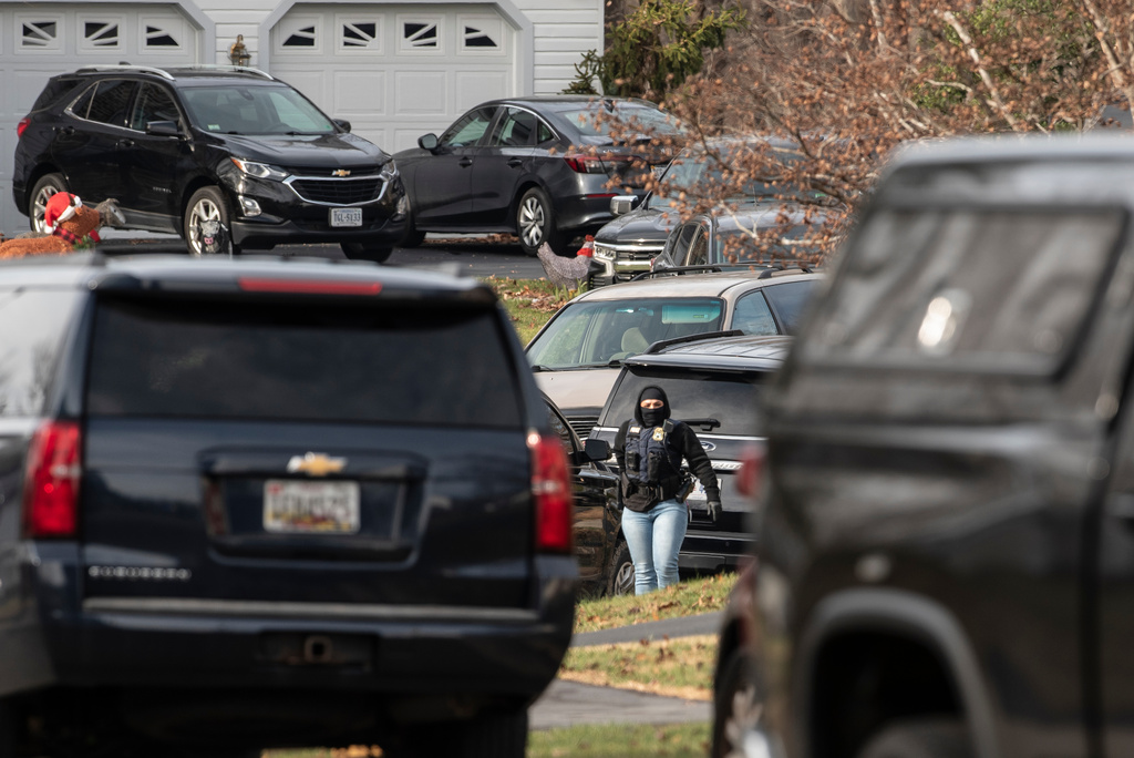 An FBI agent stands near the house where the FBI made an arrest, in Woodbridge, Va., Thursday, Dec. 4, 2025, in a nearly five-year old investigation into who placed pipe bombs in Washington before the Jan. 6, 2021 riot at the U.S. Capitol. (AP Photo/Cliff Owen)