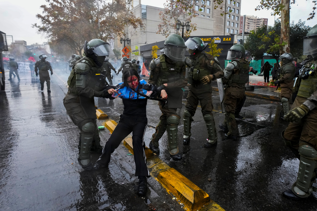 An injured student is detained by police during a protest against the government's proposal to lower the education budget, in Santiago, Chile, Wednesday, June 3, 2026. (AP Photo/Esteban Felix)