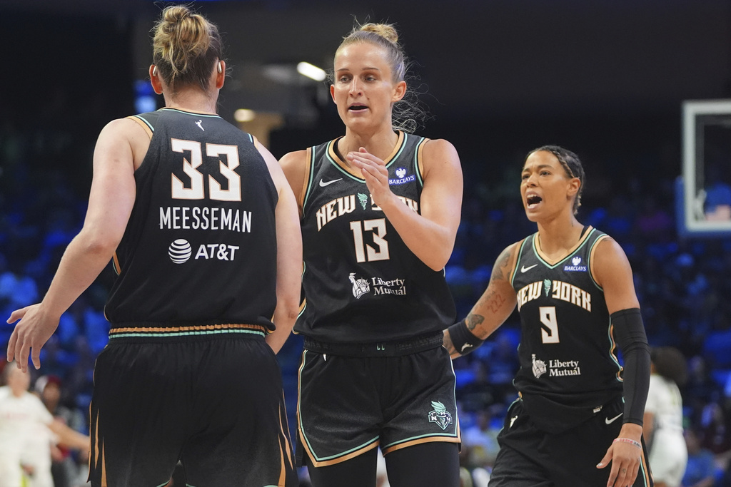 New York Liberty forward Leonie Fiebich (13) celebrates after a score with teammate center Emma Meesseman (33) and guard Natasha Cloud (9) during the first half of a WNBA basketball game against the Dallas Wings in Arlington, Texas, Friday, Aug. 8, 2025. (AP Photo/LM Otero)