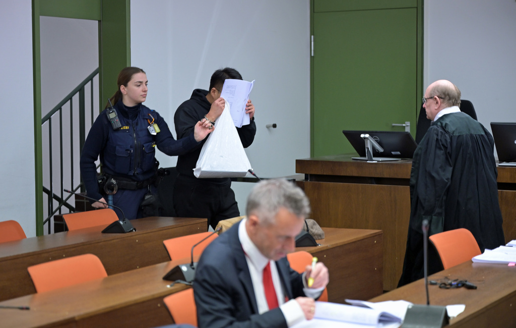 The defendant covers his face as he arrives for a trial against a network of mostly Chinese men, organized in chat groups to advise one another on how to drug and rape mostly Chinese women, in Munich, Germany, Feb. 2, 2026. (Malin Wunderlich/dpa via AP)