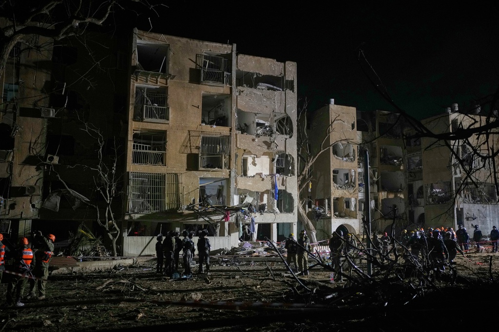 Israeli security forces and rescue teams work at the site struck by an Iranian missile in Arad, southern Israel, Sunday, March 22, 2026. (AP Photo/Ohad Zwigenberg)