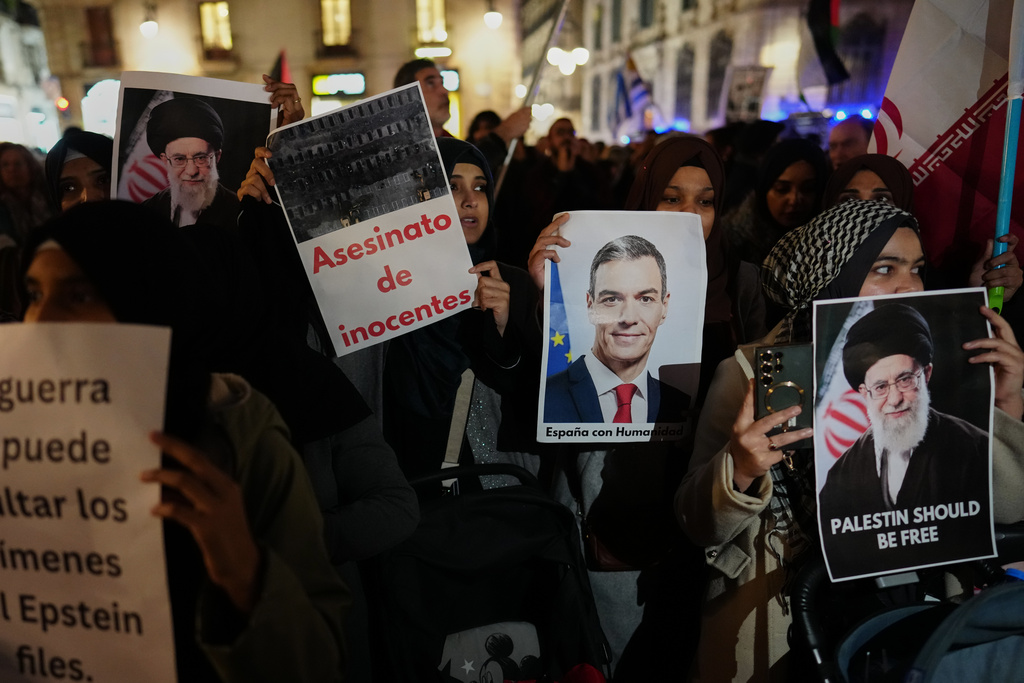 Demonstrators hold photographs of Spanish Prime Minister Pedro Sanchez during a protest against U.S. and Israeli intervention in Iran in Barcelona, Spain, Wednesday, March 4, 2026. (AP Photo)