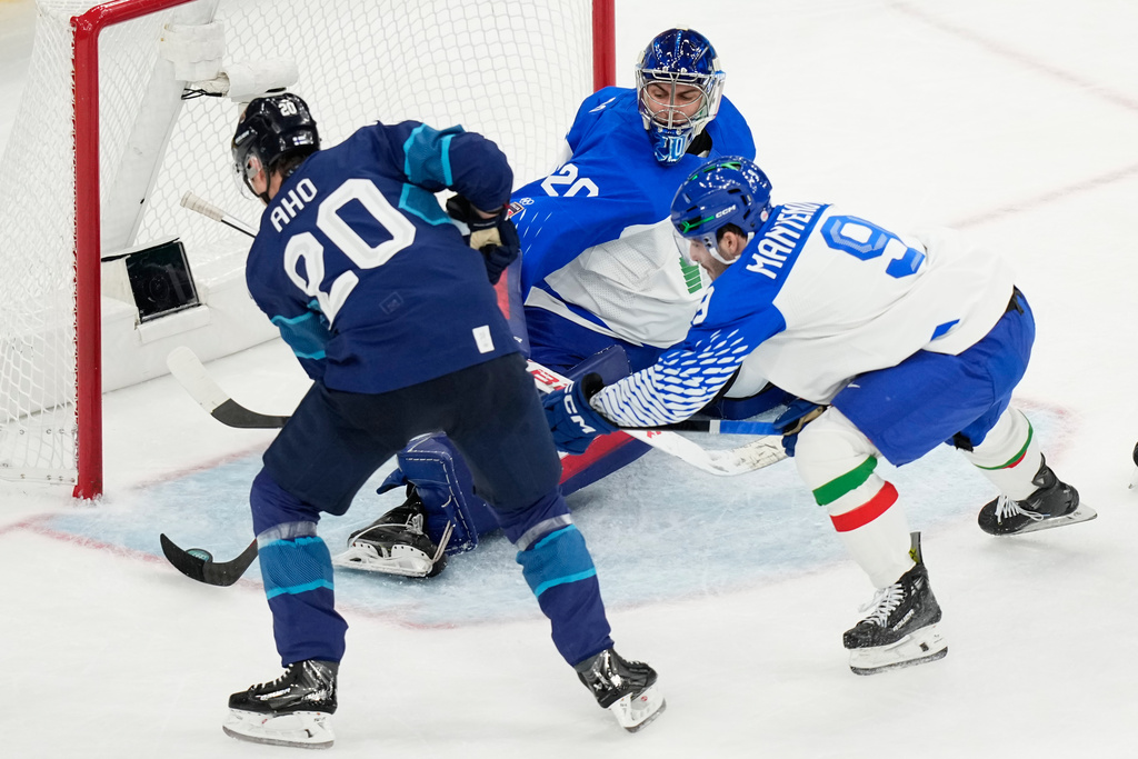 Finland's Sebastian Aho, left, scores his sides first goal past Italy's goalkeeper Damian Clara during a preliminary round match of men's ice hockey between Finland and Italy at the 2026 Winter Olympics, in Milan, Italy, Saturday, Feb. 14, 2026. (AP Photo/Hassan Ammar)