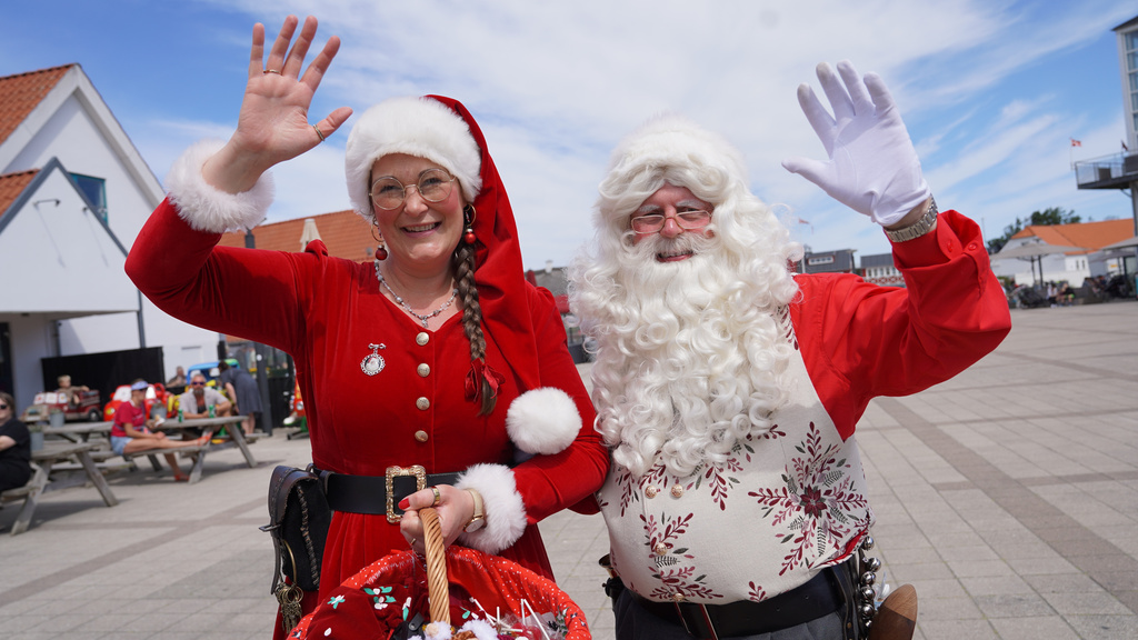 A Santa Claus and Christmas elve performer wave into the camera during the annual World Santa Claus Congress, a colorful midsummer tradition, in Aalborg, Denmark, Wednesday July 8, 2026. (AP Photo/James Brooks)