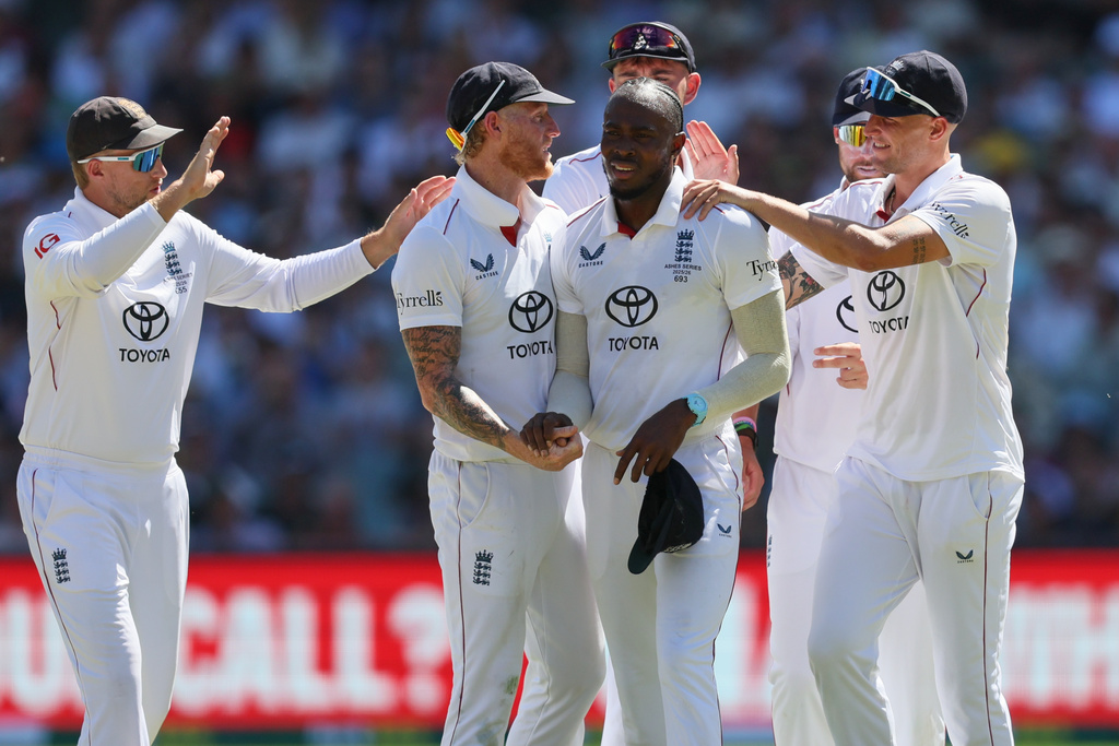 England's Jofra Archer, centre, is congratulated by teammates after taking five wickets during play on day two of the third Ashes cricket test between England and Australia in Adelaide, Australia, Thursday, Dec. 18, 2025. (AP Photo/James Elsby)