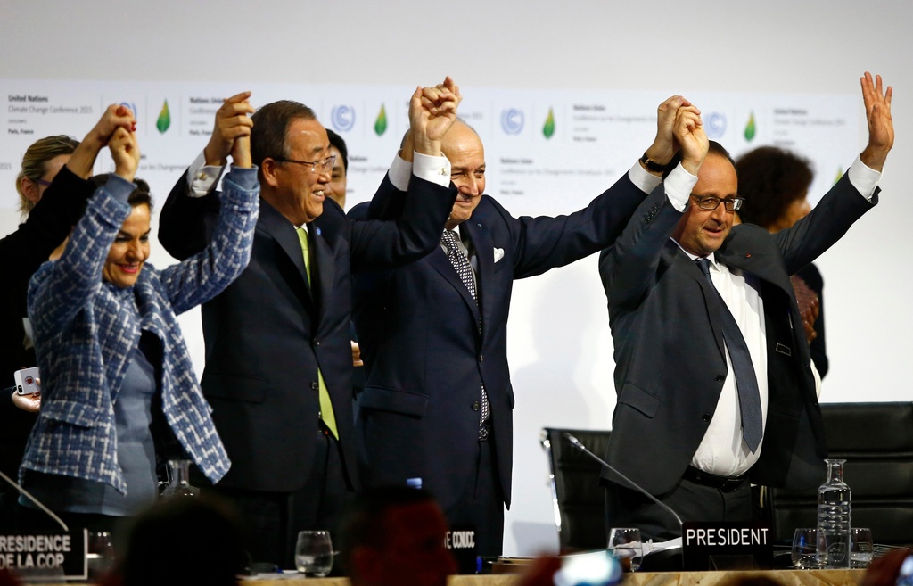 FILE - French President Francois Hollande, right, French Foreign Minister and president of the COP21 Laurent Fabius, second right, United Nations climate chief Christiana Figueres, left, and U.N. Secretary General Ban Ki-moon hold their hands up in celebration at the end of the U.N. COP21 Climate Summit in Le Bourget, France on Dec. 12, 2015. (AP Photo/Francois Mori, File)