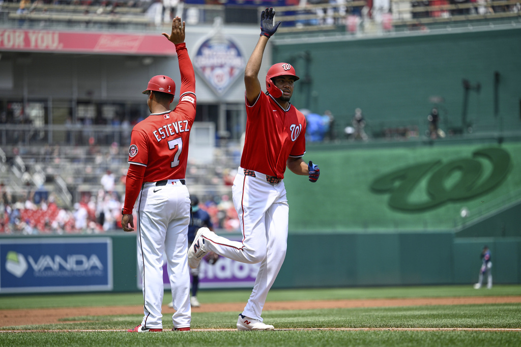 Washington Nationals' James Wood, right, celebrates his home run with third base coach Victor Estevez (7) during the first inning of a baseball game against the Seattle Mariners, Sunday, June 14, 2026, in Washington. (AP Photo/Nick Wass)