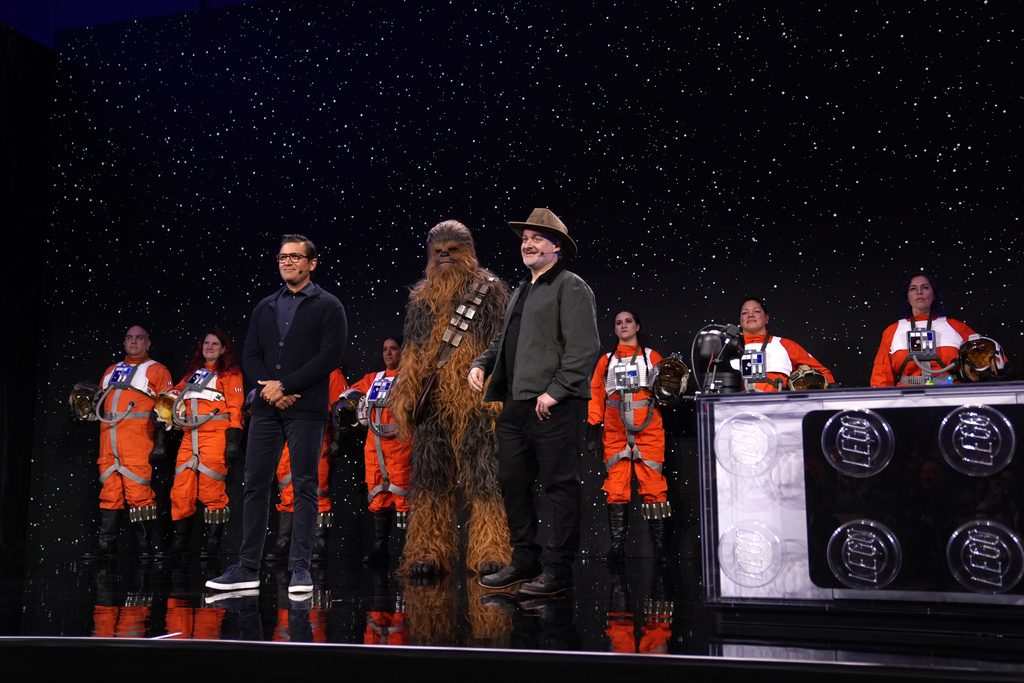 Asad Ayaz, left, and Dave Filioni stand on stage during an LEGO news conference ahead of the CES tech show Monday, Jan. 5, 2026, in Las Vegas. (AP Photo/Abbie Parr)