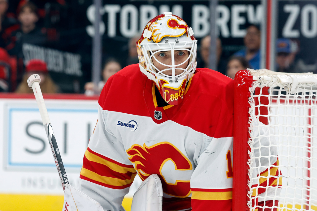 Calgary Flames goaltender Devin Cooley watches the puck against the Carolina Hurricanes during the second period of an NHL hockey game in Raleigh, N.C., Sunday, Nov. 30, 2025. (AP Photo/Karl DeBlaker)