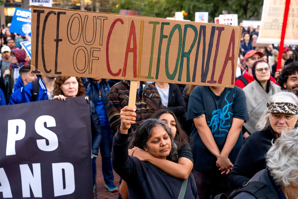 A mother and daughter, who declined to give their names, join protesters against immigration raids in San Francisco on Thursday, Oct. 23, 2025. (AP Photo/Noah Berger)