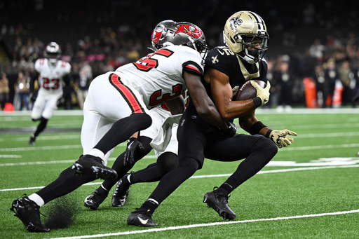 New Orleans Saints wide receiver Chris Olave (12) is stopped by Tampa Bay Buccaneers cornerback Jamel Dean (35) and safety Antoine Winfield Jr. during the second half of an NFL football game Sunday, Oct. 26, 2025, in New Orleans. (AP Photo/Ella Hall) New Orleans Saints wide receiver Chris Olave (12) is stopped by Tampa Bay Buccaneers cornerback Jamel Dean (35) and safety Antoine Winfield Jr. during the second half of an NFL football game Sunday, Oct. 26, 2025, in New Orleans. (AP Photo/Ella Hall)