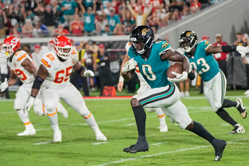 Jacksonville Jaguars linebacker Devin Lloyd (0) runs the ball 99 yards for a touchdown after intercepting a pass during the second half of an NFL football game against the Kansas City Chiefs, Monday, Oct. 6, 2025, in Jacksonville, Fla. (AP Photo/John Raoux)