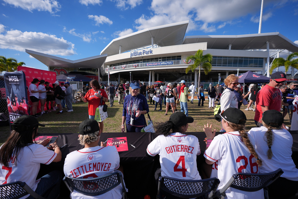 Fans interact with Women's Pro Baseball League players at a fan fest event ahead of a spring training game between the Boston Red Sox and the Minnesota Twins, Thursday, March 19, 2026, in Fort Myers, Fla. (AP Photo/Rebecca Blackwell)