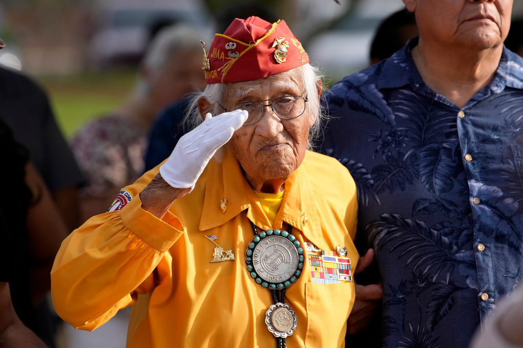 Navajo Code Talker Thomas Begay salutes during the national anthem during a ceremony on Navajo Code Talkers Day, Friday, Aug. 14, 2026, in Phoenix. (AP Photo/Ross D. Franklin)