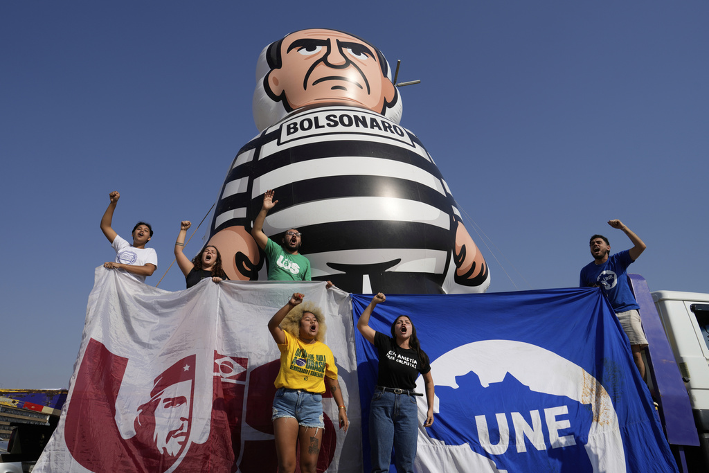 University students display an inflatable doll of Brazil's former President Jair Bolsonaro wearing prisoner garb in Brasilia, Brazil, Friday, Sept. 12, 2025, the morning after the Supreme Court convicted and sentenced him to prison for attempting a coup to remain in office despite his 2022 electoral defeat. (AP Photo/Eraldo Peres)