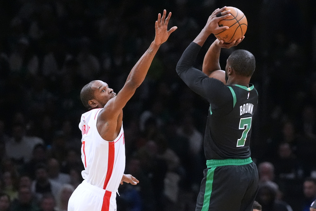 Houston Rockets forward Kevin Durant, left, tries to block a shot by Boston Celtics forward Jaylen Brown (7) during the second half of an NBA basketball game, Saturday, Nov. 1, 2025, in Boston. (AP Photo/Charles Krupa)