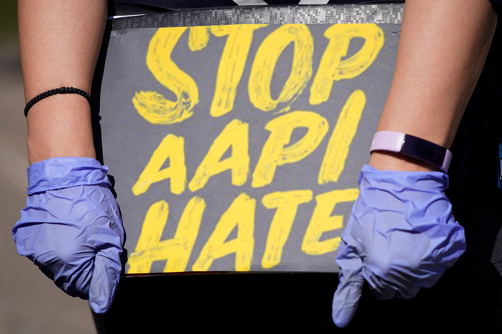 FILE - A person holds a sign and attends a rally to support Stop AAPI (Asian Americans and Pacific Islanders) Hate at the Logan Square Monument in Chicago, March 20, 2021. (AP Photo/Nam Y. Huh, File)