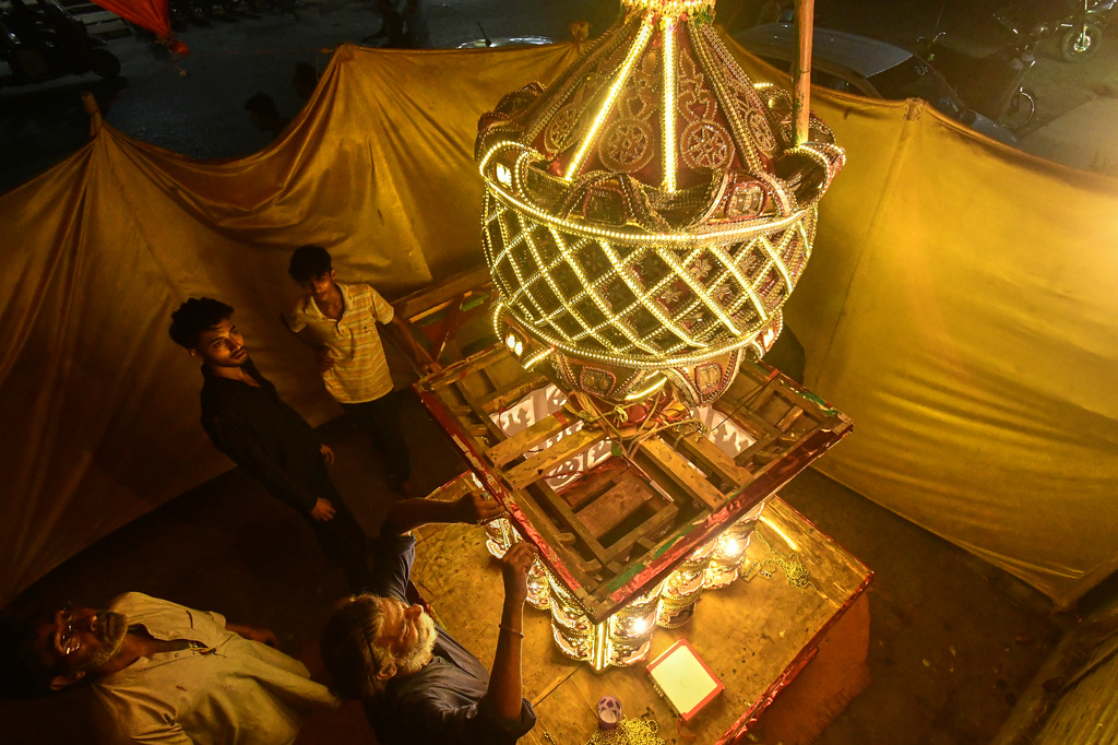 Artisans from Pakistani Hindu community, give final touches to a replica of the mausoleum of Imam Hussain locally called 'Tazia', in preparation for the upcoming Ashoura, when Shiites Muslims mark the death of Hussein, at their home in Karachi, Pakistan, Tuesday, June 23, 2026. (AP Photo/Ali Raza)