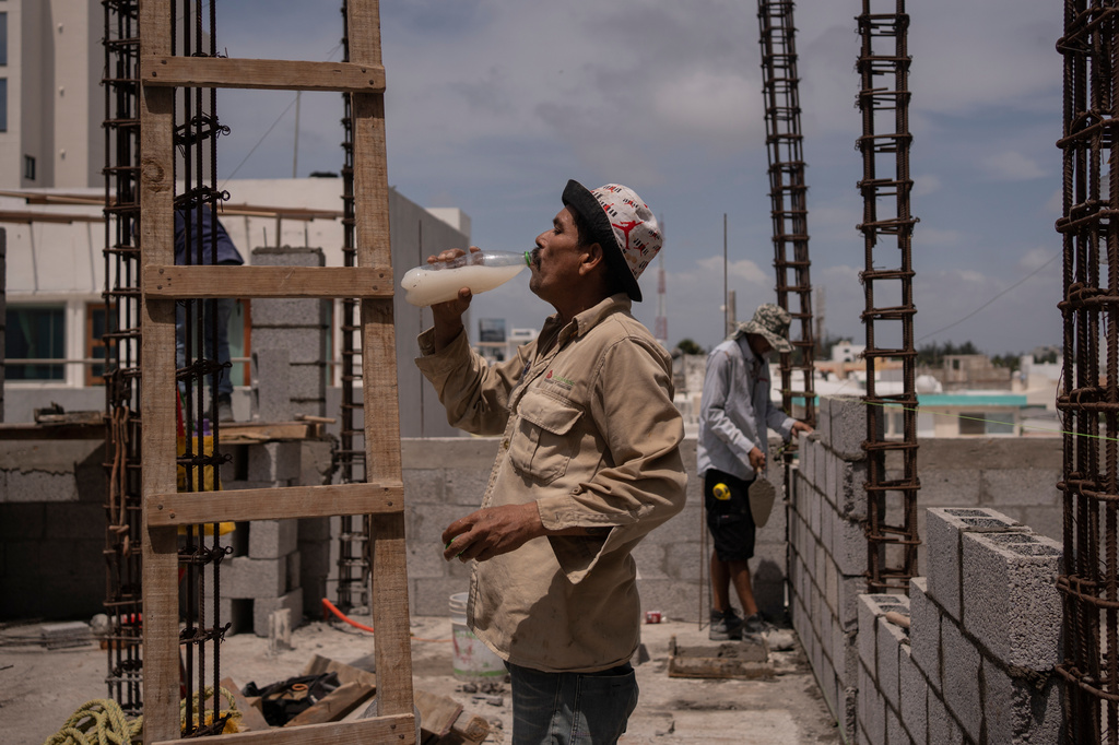 FILE - Jorge Moreno, a worker, drinks flavored water to cope with the heat wave during his workday at a construction site in Veracruz, Mexico, on June 17, 2024. (AP Photo/Felix Marquez, File)