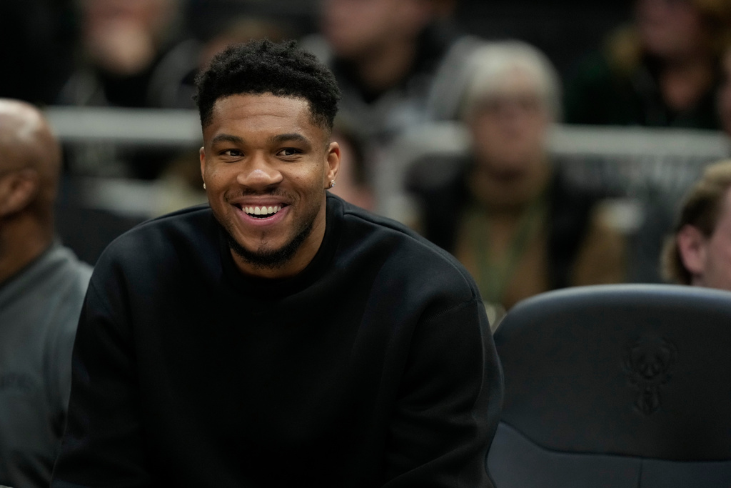 Milwaukee Bucks' Giannis Antetokounmpo smiles from the bench during the first half of an NBA basketball game against the Boston Celtics, Thursday, Dec. 11, 2025, in Milwaukee. (AP Photo/Aaron Gash)