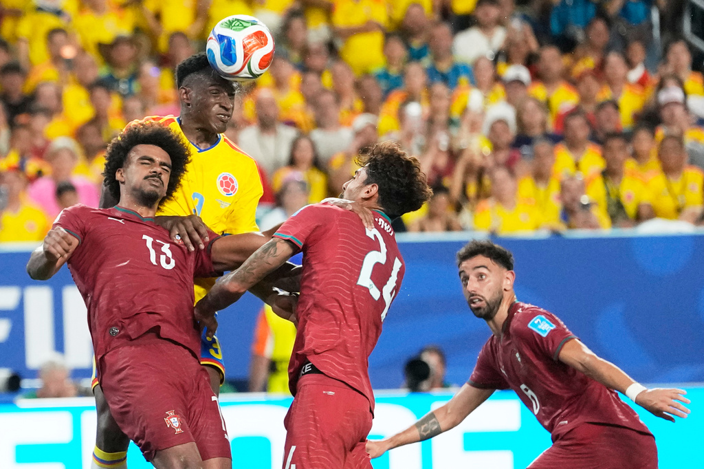 Colombia's Jhon Lucumi (3) leaps above Portugal's Renato Veiga (13) and Samu Costa (24) to head the ball during the World Cup Group K soccer match between Colombia and Portugal in Miami Gardens, Fla., Saturday, June 27, 2026. (AP Photo/Rebecca Blackwell)