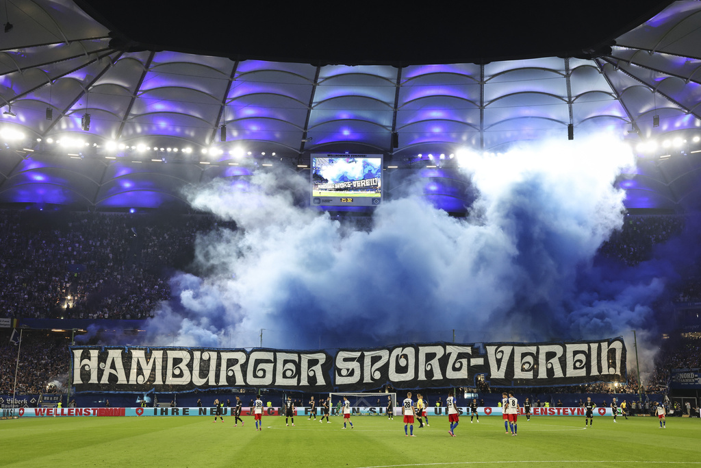 Hamburger SV fans celebrate their team with colored smoke at the start of the second half of the German Bundesliga soccer match between Hamburger SV and FC St. Pauli at Volksparkstadion in Hamburg, Germany, Friday, Aug. 29, 2025. (Christian Charisius/dpa via AP)