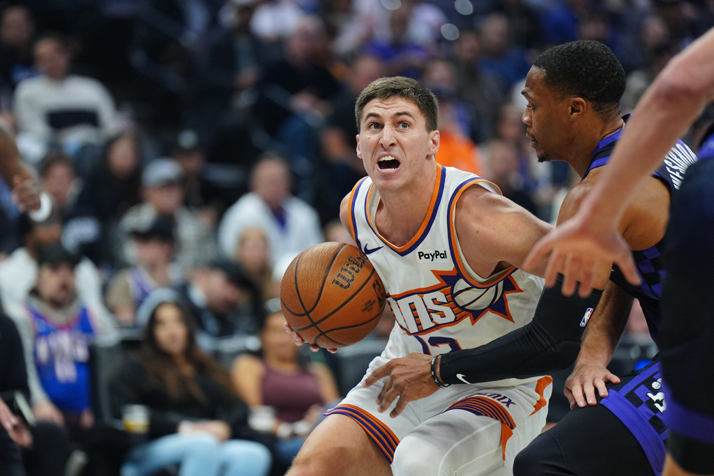 Phoenix Suns guard Collin Gillespie (12) drives to the basket against Sacramento Kings guard Russell Westbrook (18) during the first half of an Emirates NBA Cup basketball game Wednesday, Nov. 26, 2025, in Sacramento, Calif. (AP Photo/Alan Greth)