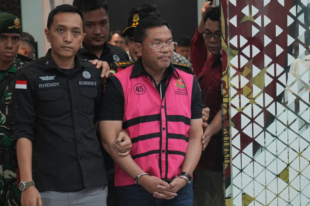 Former deputy head of Indonesia's National Nutrition Agency Sony Sonjaya, center, is escorted by prosecutors to a waiting detention car after being named as a corruption suspect, at the Attorney Genera's Office in Jakarta, Indonesia, Wednesday, June 3, 2026. (AP Photo/Achmad Ibrahim)