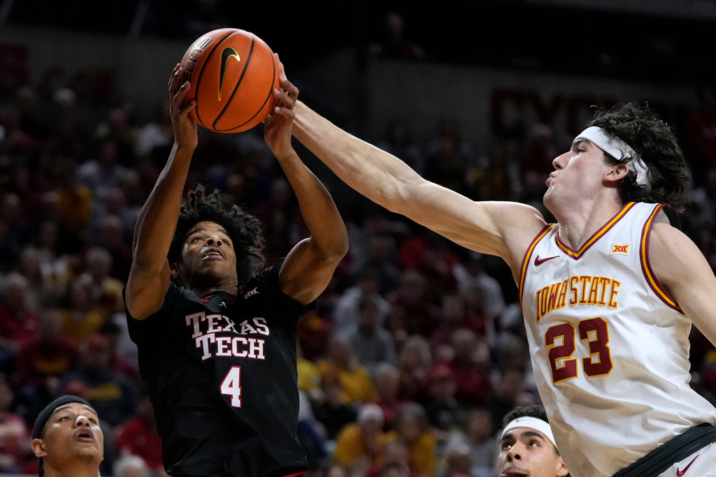 Texas Tech guard Christian Anderson (4) fights for a rebound with Iowa State forward Blake Buchanan (23) during the first half of an NCAA college basketball game, Saturday, Feb. 28, 2026, in Ames, Iowa. (AP Photo/Charlie Neibergall)