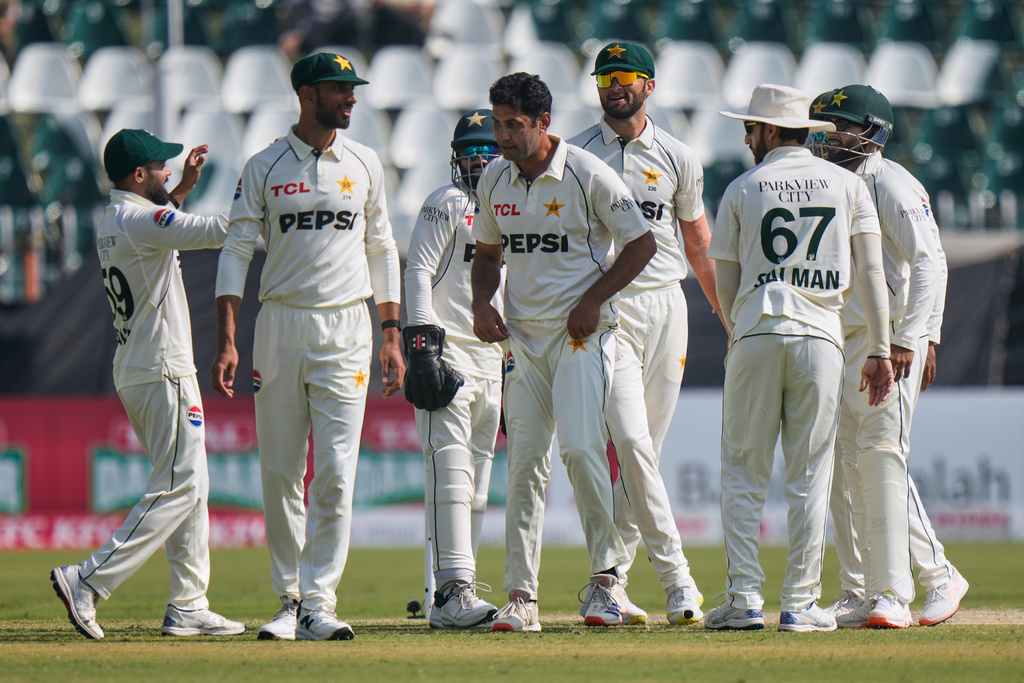 Pakistan's Asif Afridi, center, is congratulated by teammates after taking his fifty wicket to dismiss South Africa's Simon Harmer during the third day of the second test cricket match between Pakistan and South Africa, in Rawalpindi, Pakistan, Wednesday, Oct. 22, 2025. (AP Photo/Anjum Naveed)