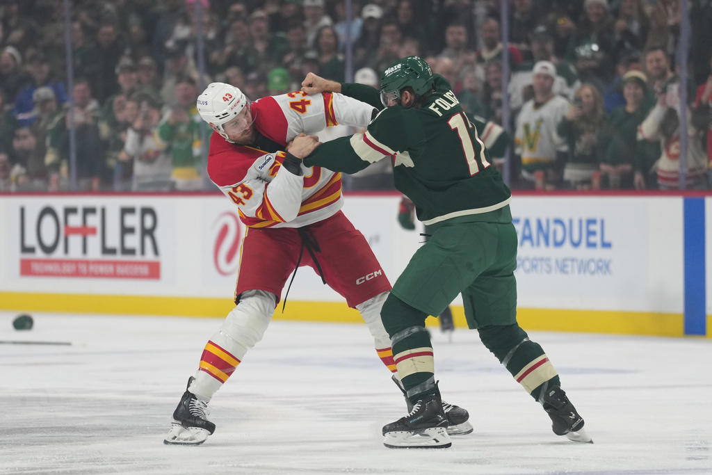 Calgary Flames right wing Adam Klapka (43) and Minnesota Wild left wing Marcus Foligno (17) fight during the first period of an NHL hockey game, Thursday, Jan. 29, 2026, in St. Paul, Minn. (AP Photo/Abbie Parr)