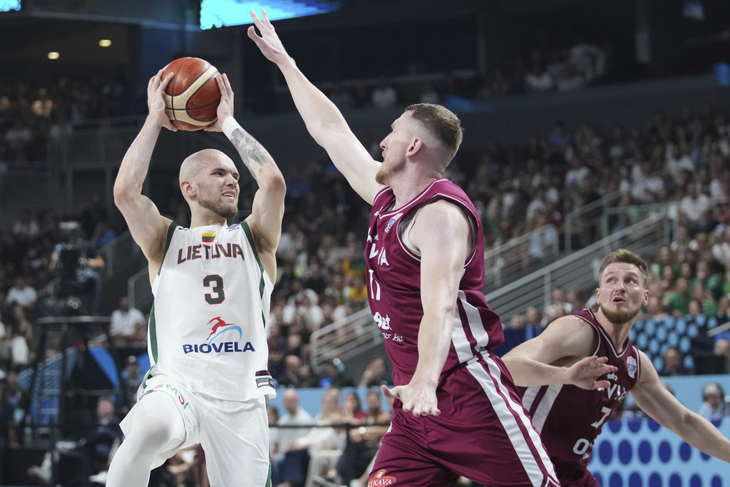 Lithuania's Arnas Velicka, left, tries to shoot while defended by Latvia's Rolands Smits during the Eurobasket, European Basketball Championship round of 16 match between Lithuania and Latvia at the Riga Arena in Riga, Latvia, Saturday, Sept. 6, 2025. (AP Photo/Sergei Grits)