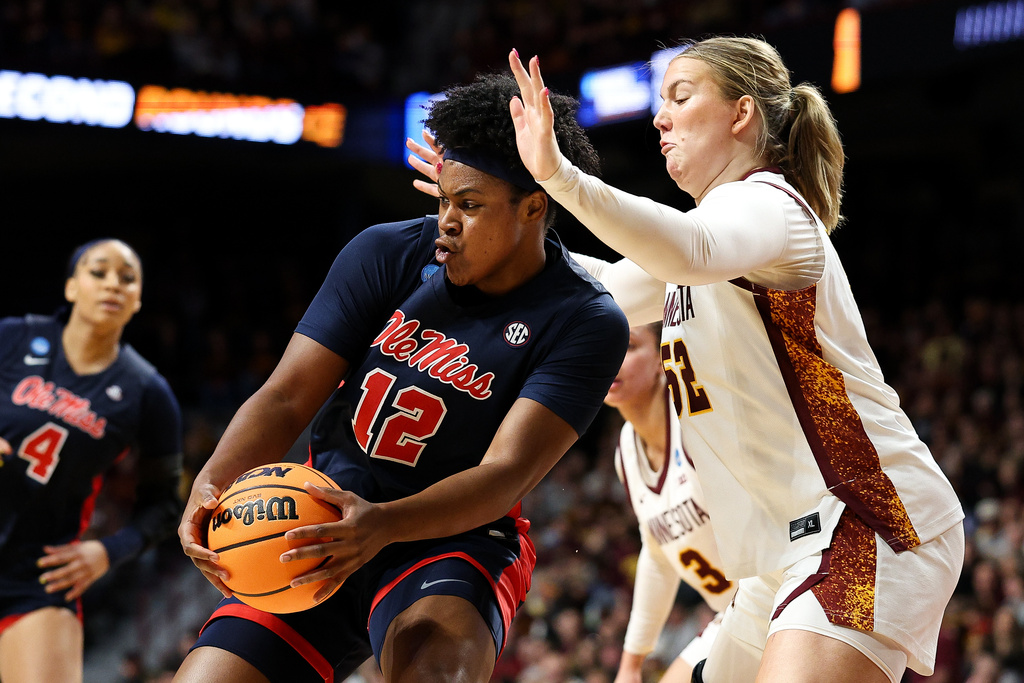 Mississippi forward Christeen Iwuala (12) drives toward the basket as Minnesota center Sophie Hart, right, defends during the first half in the second round of the NCAA college basketball tournament, Sunday, March 22, 2026, in Minneapolis. (AP Photo/Matt Krohn)