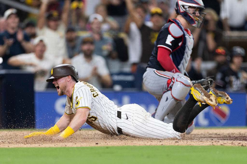 San Diego Padres' Jake Cronenworth, left, scores on an error by Minnesota Twins third baseman Brooks Lee (not shown) in the seventh inning of a baseball game Saturday, Aug. 22, 2026, in San Diego. (AP Photo/Karl Anderson)