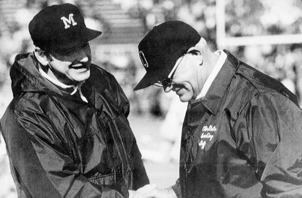 FILE - In this undated photo, Michigan coach Bo Schembechler, left, meets with Ohio State coach Woody Hayes at an NCAA college football game. (AP Photo/File)