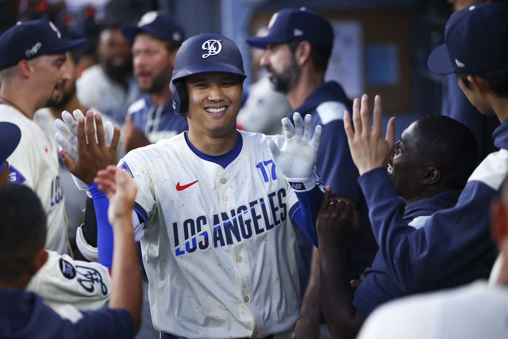 Los Angeles Dodgers' Shohei Ohtani celebrates in the dugout with his teammates after hitting a home run during the fifth inning of a baseball game against the Toronto Blue Jays, Saturday, Aug. 9, 2025, in Los Angeles. (AP Photo/Jessie Alcheh)