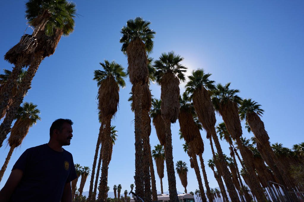 Rubin Pantaleon stays in the shade while waiting for work washing car windshields as a record-breaking winter heat wave continues across the Southwest, Thursday, March 19, 2026, in Thermal, Calif. (AP Photo/Gregory Bull)
