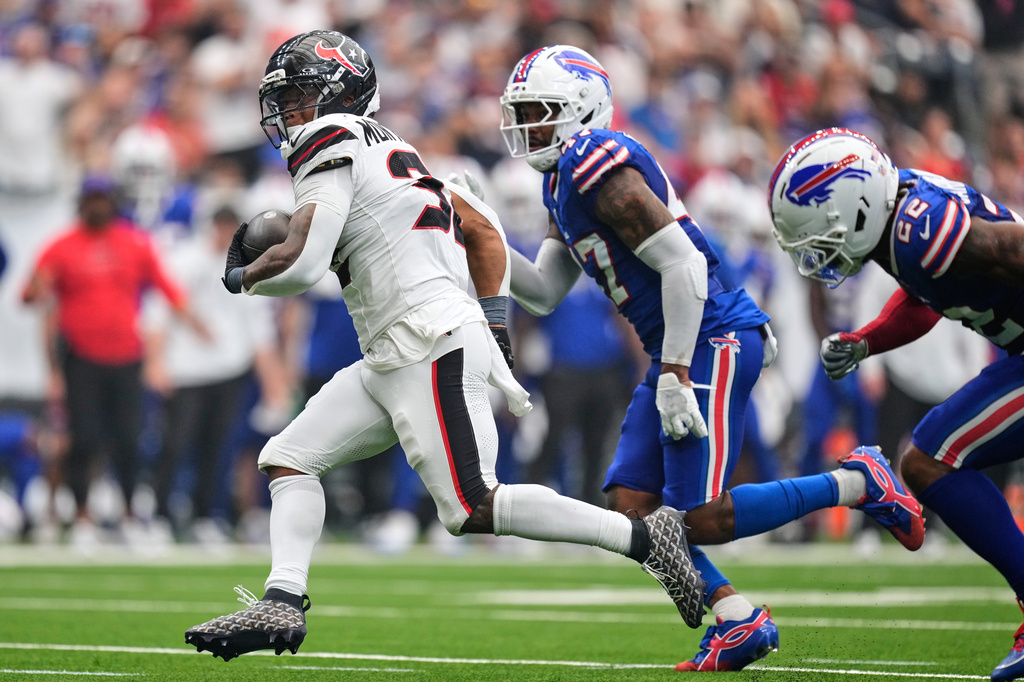 Houston Texans running back David Montgomery, left, runs the ball past Buffalo Bills cornerback Christian Benford, center, and safety C.J. Gardner-Johnson (22) for a touchdown during the first half of an NFL football game, Sunday, Sept. 13, 2026, in Houston. (AP Photo/Ashley Landis)
